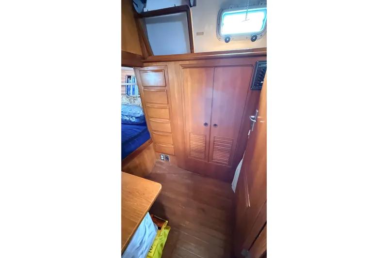 Slide: The Image of Interior of 1983 Tanton 44 sailboat with wooden cabinetry and cozy sleeping area. - 23