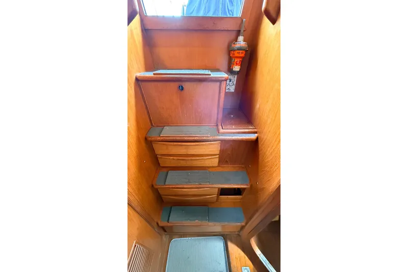 Slide: The Image of Wooden interior stairs of a 1983 Tanton 44 boat with safety equipment. - 26