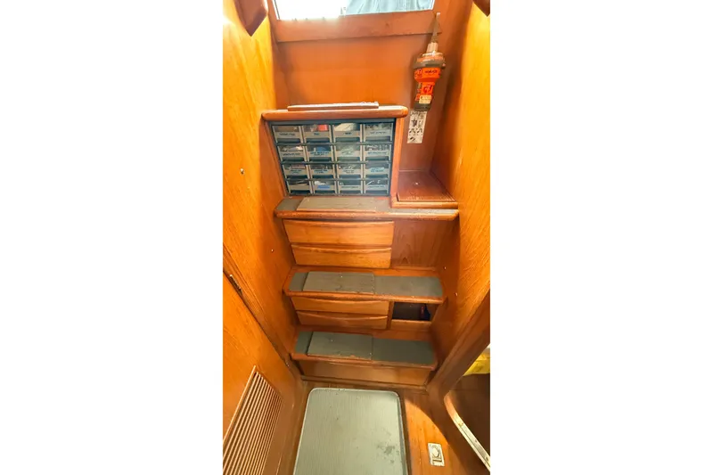 Slide: The Image of Wooden interior of 1983 Tanton 44 sailboat with storage compartments and steps. - 27
