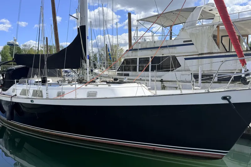 Slide: The Image of 1983 Tanton 44 sailboat docked at marina, clear sky, calm water. - 31