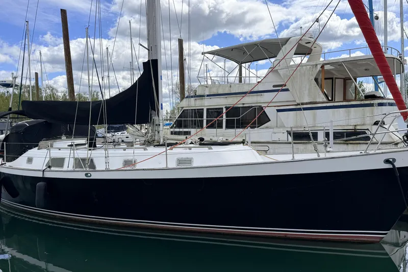 Slide: The Image of 1983 Tanton 44 sailboat docked in marina under cloudy sky. - 32