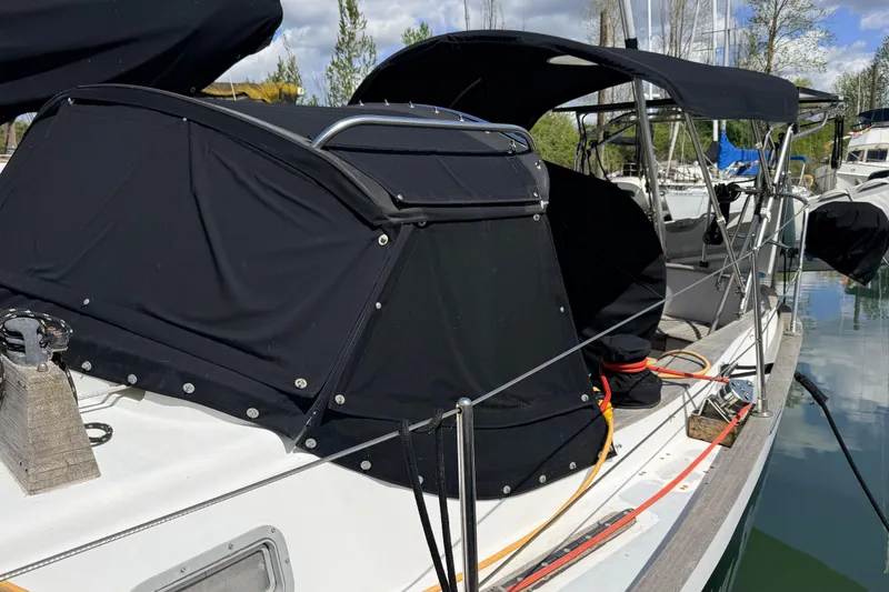 Slide: The Image of 1983 Tanton 44 sailboat with black canvas cover docked at marina. - 37