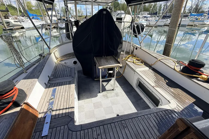 Slide: The Image of Cockpit of 1983 Tanton 44 sailboat docked in marina, featuring wooden deck and covered helm. - 39