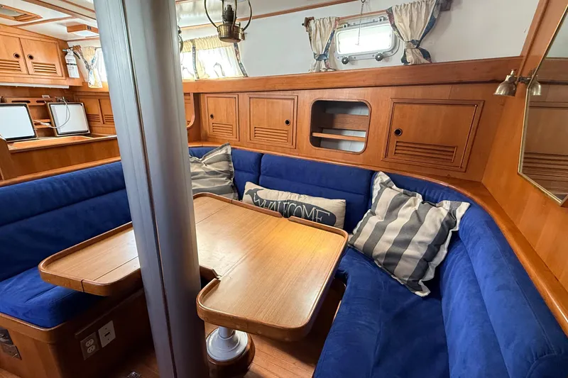 Slide: The Image of Cozy 1983 Tanton 44 yacht interior with blue seating and wooden accents. - 4