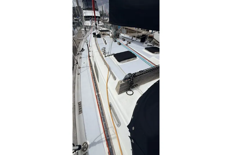 Slide: The Image of 1983 Tanton 44 sailboat deck with rigging and hatches in a marina setting. - 42