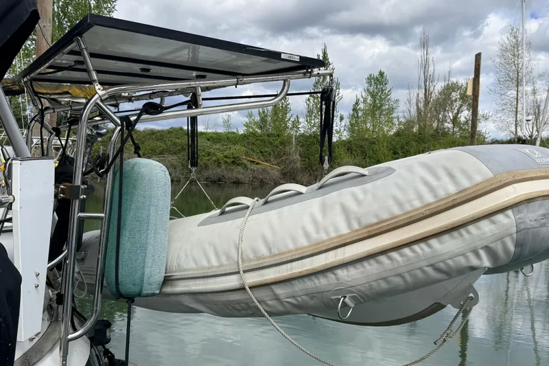 Slide: The Image of Inflatable boat on Tanton 44 sailboat, 1983 model, docked by lush greenery. - 49