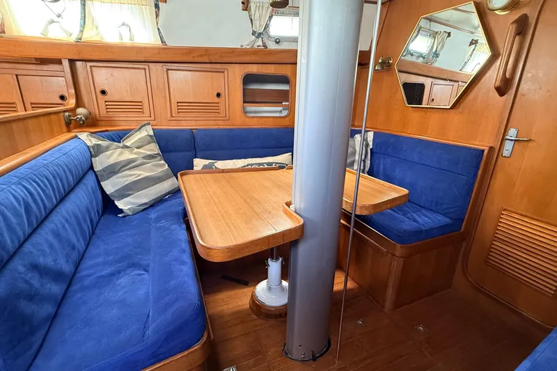 Slide: The Image of Cozy 1983 Tanton 44 yacht interior with blue seating and wooden accents. - 5