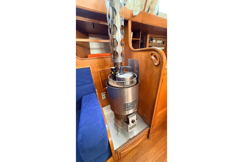 Slide: The Image of Wood-paneled interior of 1983 Tanton 44 yacht with a metal stove and blue seating. - 7