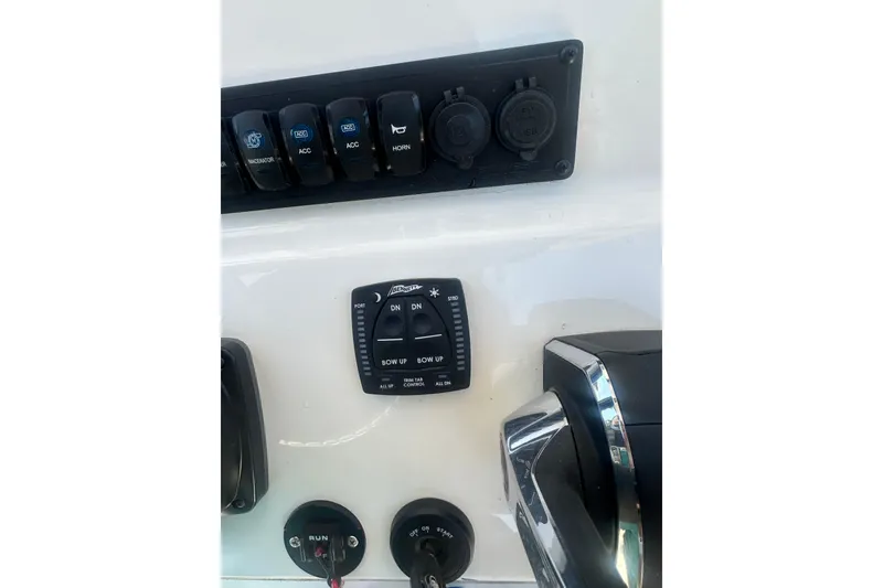 Slide: The Image of Control panel of 2026 Key West 239 FS boat with switches and trim tab controls. - 16