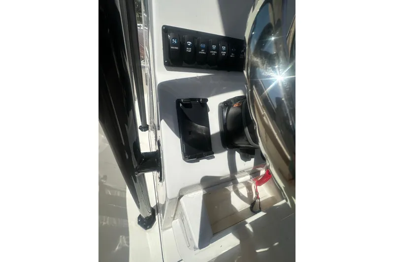 Slide: The Image of Control panel of 2026 Key West 239 FS boat with switches and steering wheel. - 17