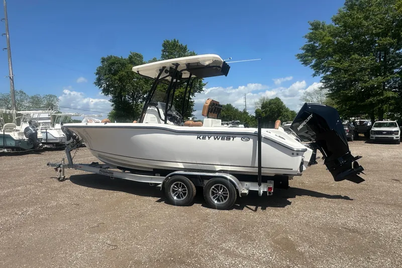 Slide: The Image of 2026 Key West 239 FS boat on trailer, parked outdoors under clear sky. - 2