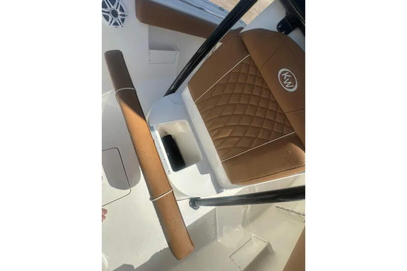 Slide: The Image of 2026 Key West 239 FS boat interior with brown quilted seating and white deck. - 29