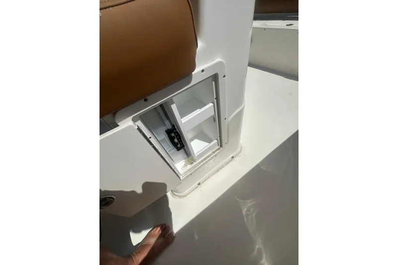Slide: The Image of Open storage compartment on 2026 Key West 239 FS boat, featuring white interior and brown seating. - 37