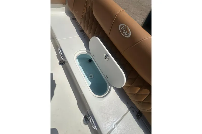 Slide: The Image of 2026 Key West 239 FS boat interior with tan seating and open storage compartment. - 41