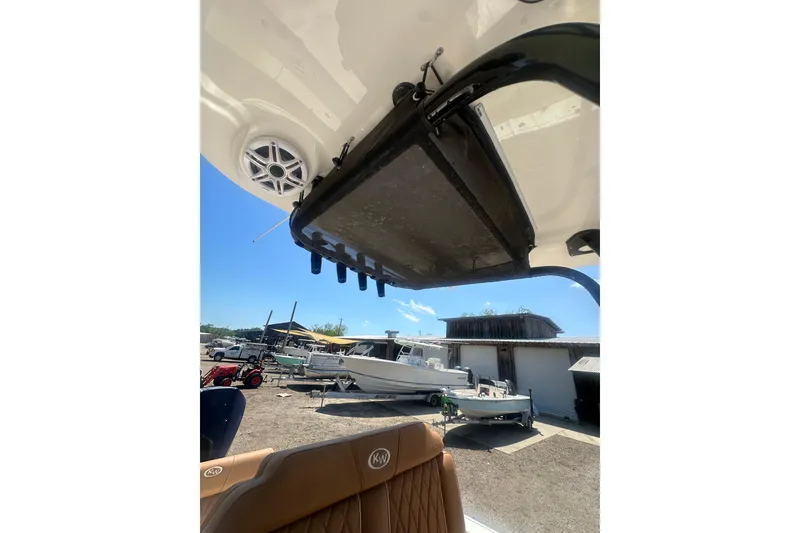 Slide: The Image of 2026 Key West 239 FS boat interior with speaker and storage, docked outdoors. - 47
