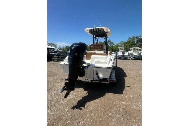 Slide: The Image of 2026 Key West 239 FS boat with outboard motor, parked on gravel lot under clear blue sky. - 5