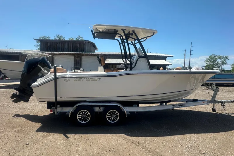 Slide: The Image of 2026 Key West 239 FS boat on trailer, parked outdoors under clear sky. - 7