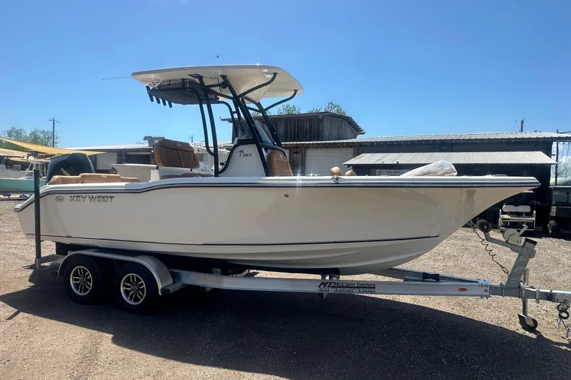 Slide: The Image of 2026 Key West 239 FS boat on trailer, parked outdoors under clear sky. - 8