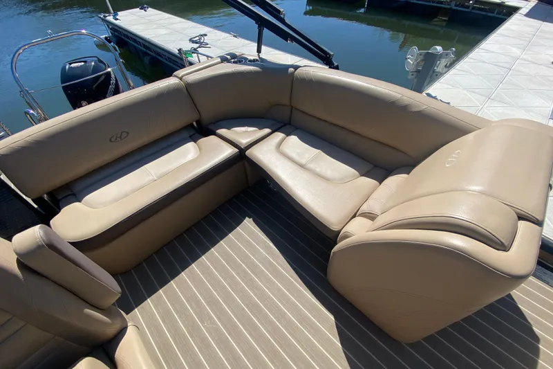 Slide: The Image of Open storage compartment in 2018 Harris Solstice 240 boat with beige seating. - 10