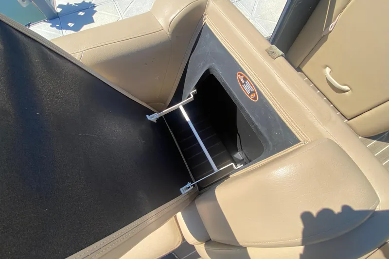 Slide: The Image of 2018 Harris Solstice 240 boat interior with tan leather seating and storage compartment. - 11