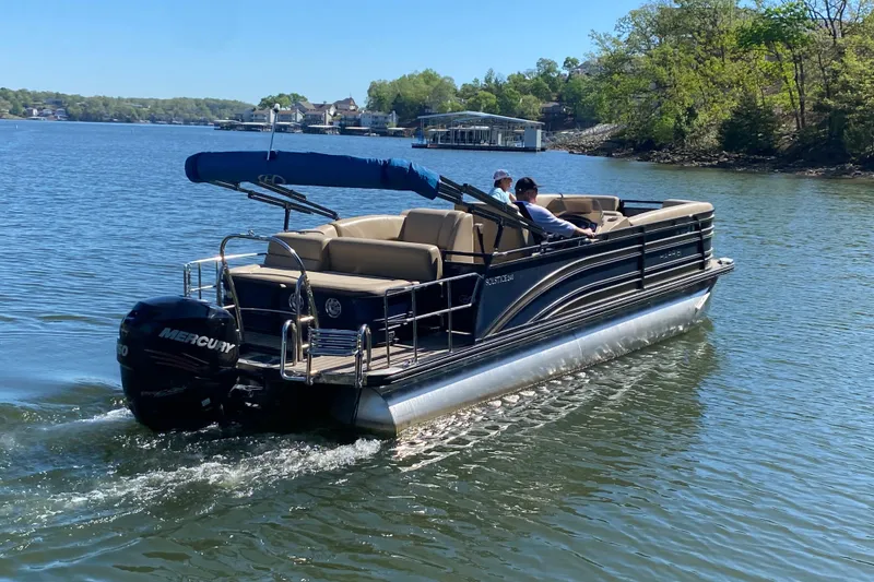 Slide: The Image of 2018 Harris Solstice 240 pontoon boat cruising on a serene lake. - 2