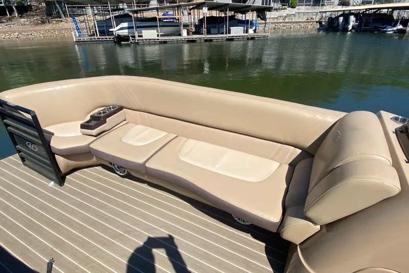 Slide: The Image of 2018 Harris Solstice 240 pontoon boat with spacious seating, docked by a serene lake. - 25