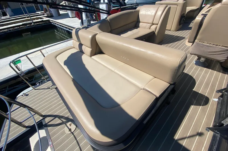 Slide: The Image of 2018 Harris Solstice 240 boat with beige seating and outboard motor at dock. - 7