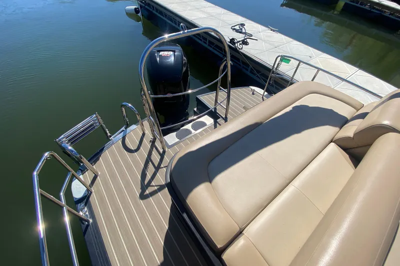 Slide: The Image of 2018 Harris Solstice 240 boat interior with beige seating and steering wheel. - 8