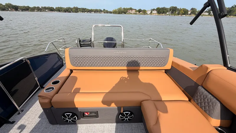Slide: The Image of The image shows the rear of a Harris Sunliner 230 pontoon boat with beige seating and speakers. - 43