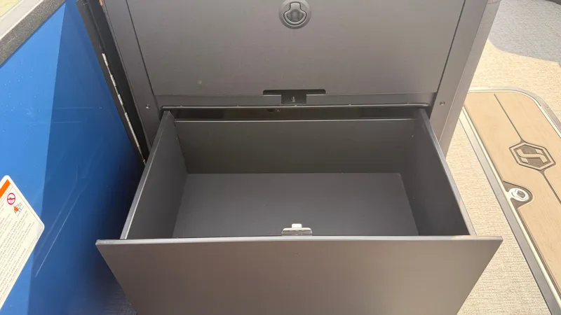 Slide: The Image of An open storage compartment on a 2027 Harris Sunliner 230 boat. - 30