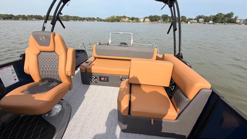 Slide: The Image of The image shows the interior of a 2027 Harris Sunliner 230 with beige seating on a lake. - 40