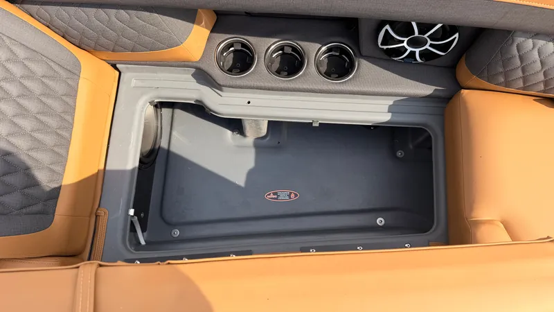 Slide: The Image of An open storage compartment on a Harris Sunliner 230 boat with speaker and cup holders. - 17