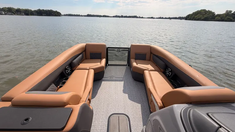 Slide: The Image of The image shows the interior of a 2027 Harris Sunliner 230 with beige seating on a calm lake. - 19