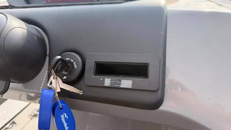 Slide: The Image of Close-up of a boat ignition switch with keychain and keys, mounted on a gray dashboard. - 36