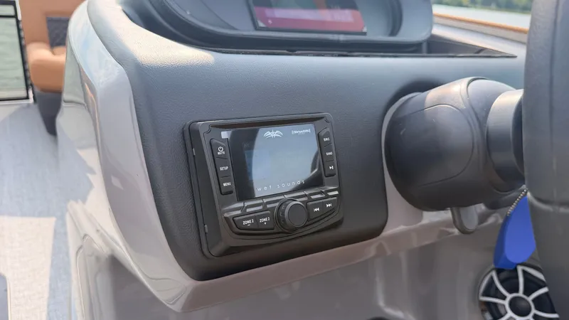 Slide: The Image of The image shows the dashboard of a 2027 Harris Sunliner 230 with an audio system. - 33