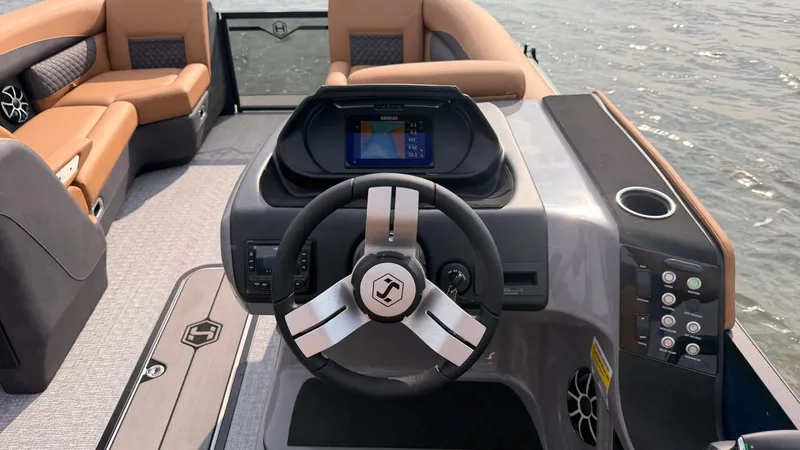 Slide: The Image of The image shows the cockpit of a 2027 Harris Sunliner 230 with a modern steering wheel and display. - 32