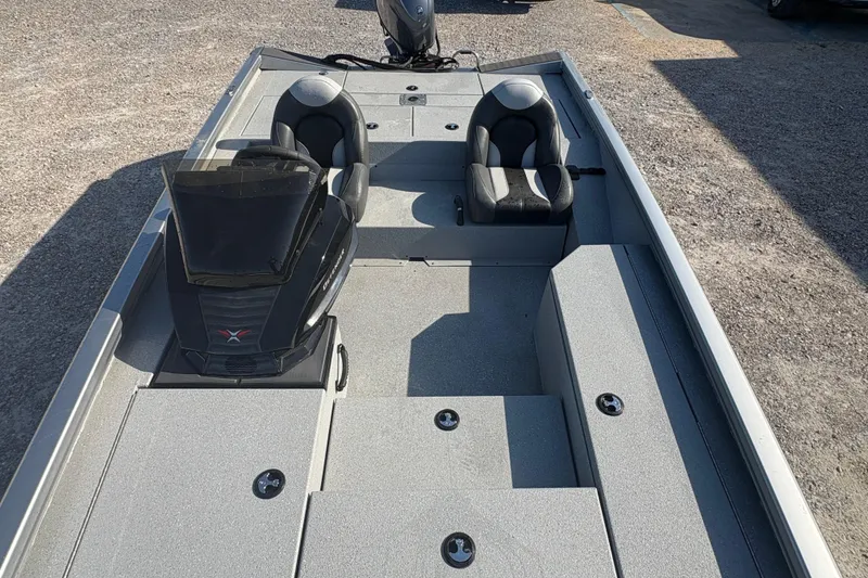 Slide: The Image of 2026 Vexus AVX181 boat interior with dual seats and console, parked on gravel. - 10