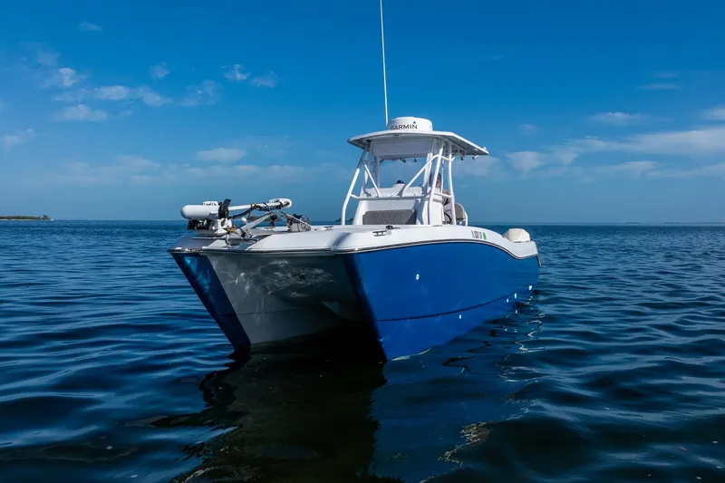 Slide: The Image of 1998 World Cat 266 SF boat on calm blue water under clear sky. - 11