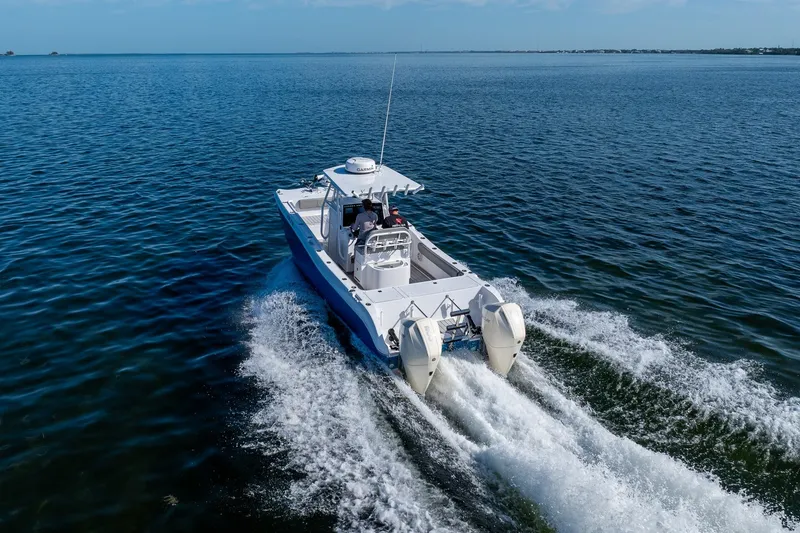 Slide: The Image of A 1998 World Cat 266 SF boat cruising on open water, showcasing twin engines. - 14