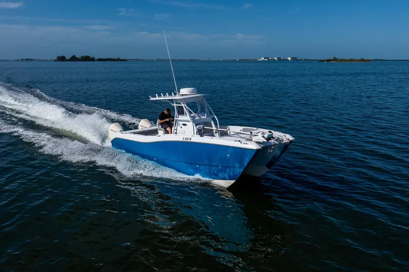 Slide: The Image of A 1998 World Cat 266 SF boat cruising on open water under a clear blue sky. - 16