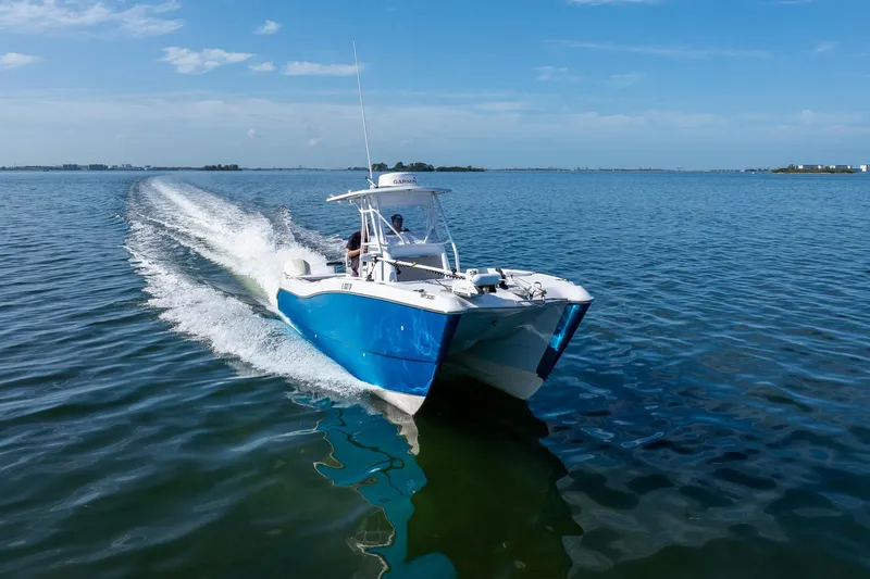 Slide: The Image of Blue 1998 World Cat 266 SF boat cruising on open water under clear skies. - 17
