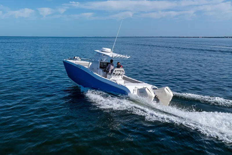 Slide: The Image of A 1998 World Cat 266 SF boat cruising on open water under a clear sky. - 20