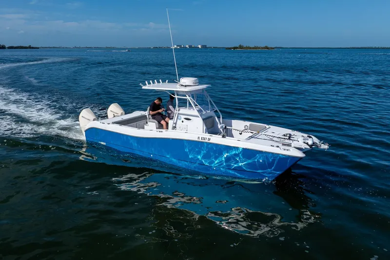Slide: The Image of A 1998 World Cat 266 SF boat cruising on open water under a clear blue sky. - 21