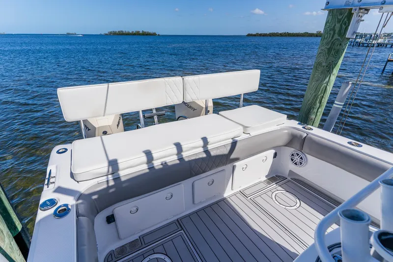 Slide: The Image of 1998 World Cat 266 SF boat interior with cushioned seating, docked by the ocean. - 22