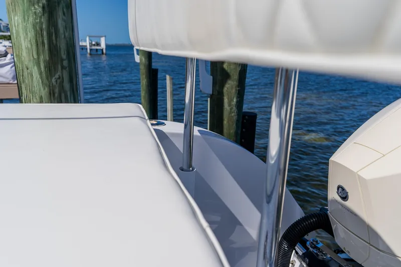 Slide: The Image of 1998 World Cat 266 SF boat docked by the water, showcasing sleek design and engine detail. - 24