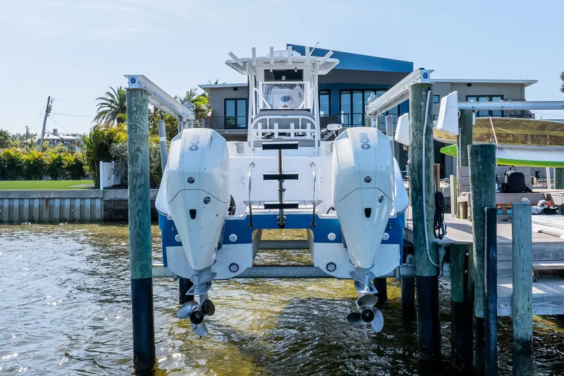 Slide: The Image of 1998 World Cat 266 SF boat with dual outboard engines docked by waterfront home. - 3