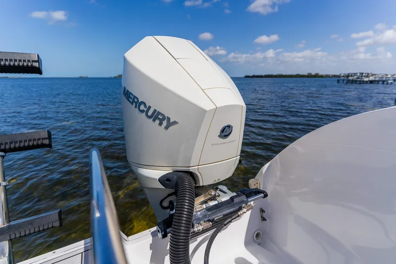 Slide: The Image of Outboard motor on 1998 World Cat 266 SF boat, overlooking serene blue waters. - 30