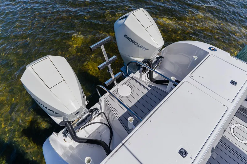 Slide: The Image of Twin Mercury outboard engines on a 1998 World Cat 266 SF boat in clear water. - 31