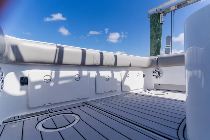 Slide: The Image of 1998 World Cat 266 SF boat interior with cushioned seating and storage compartments under a clear blue sky. - 32