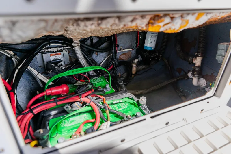Slide: The Image of Engine compartment of a 1998 World Cat 266 SF boat, featuring batteries and wiring. - 36